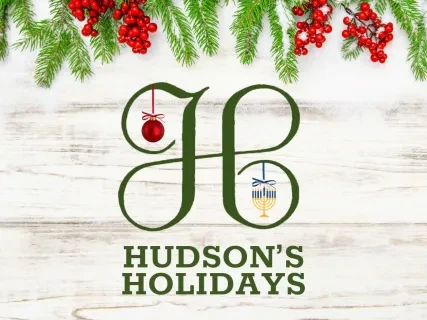 Festive logo with "H" adorned by a red bauble and glass, green pine branches, and red berries above.
