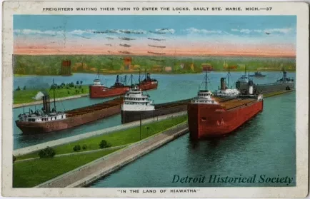 Postcard - Freighters Waiting Their Turn to Enter the Locks, Sault Ste. Marie, Mich. "In The Land of Hiawatha".