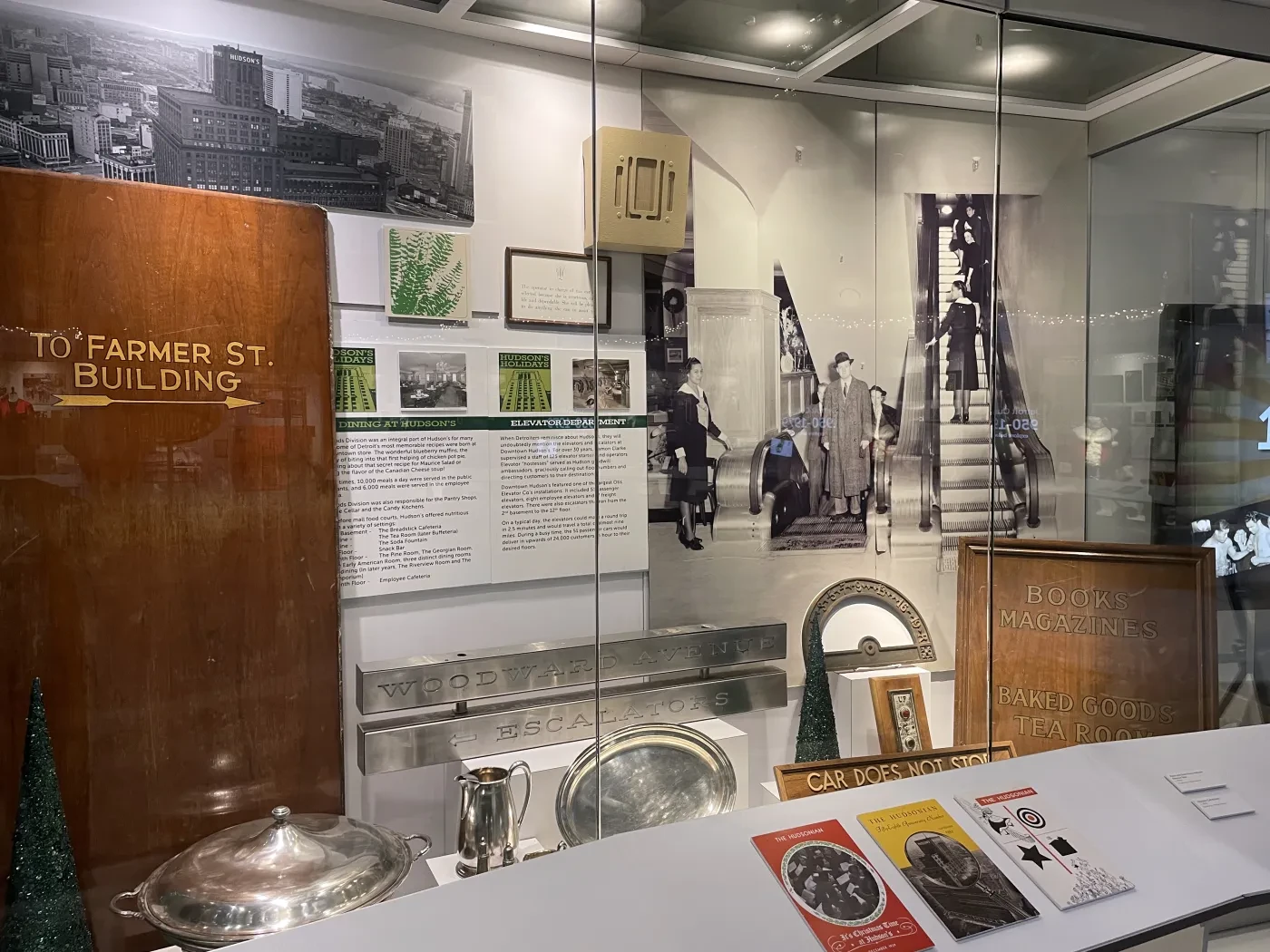 Exhibit display with historical photos, building signs, and vintage items in a museum setting.