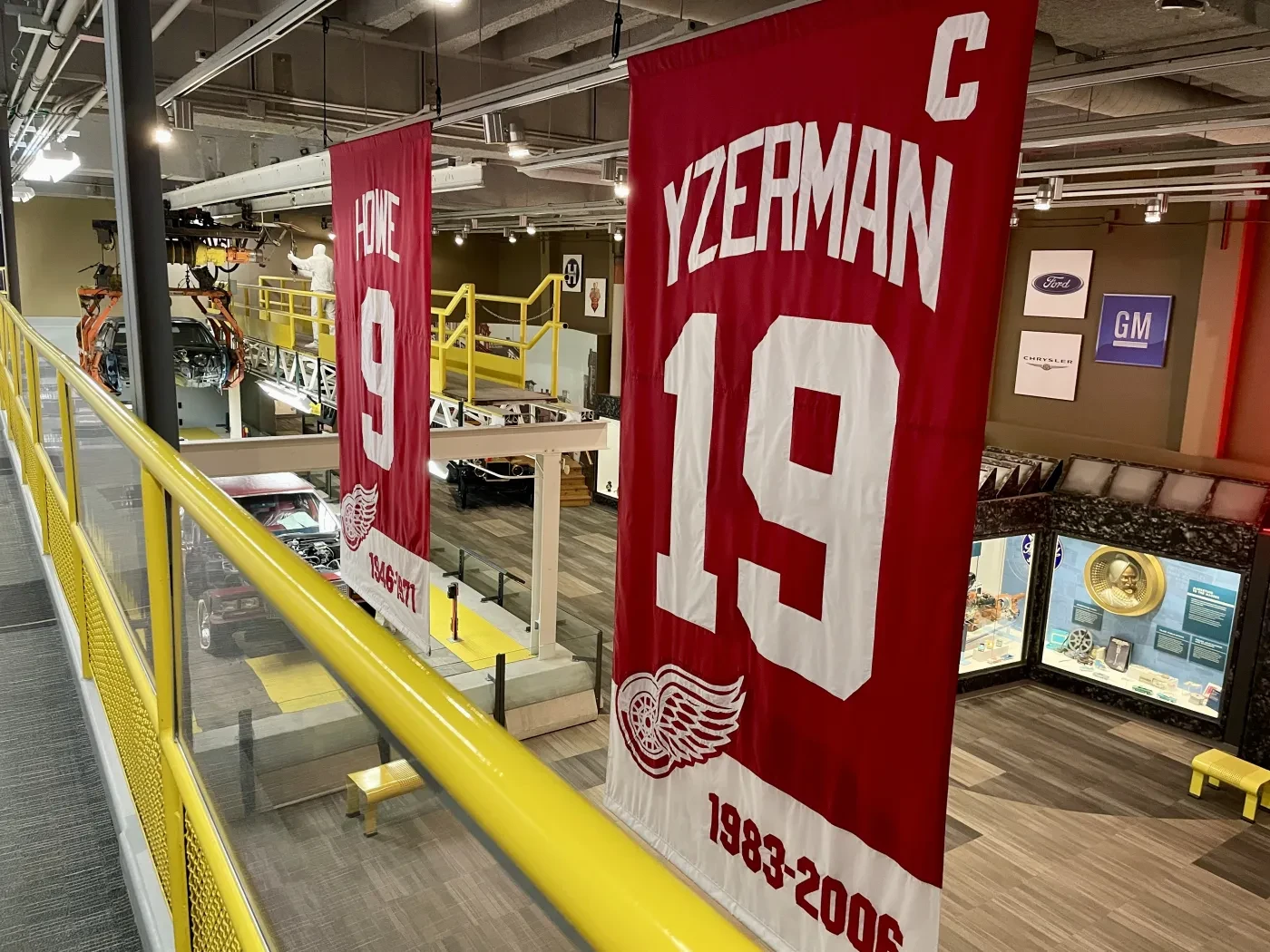 Red hockey jersey banners with numbers 19 and 9 hang in a museum-like setting.