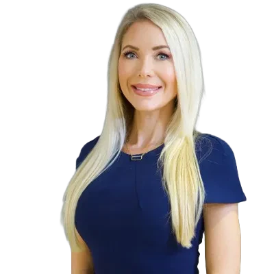Blonde woman smiling, wearing a navy blue dress against a white background.